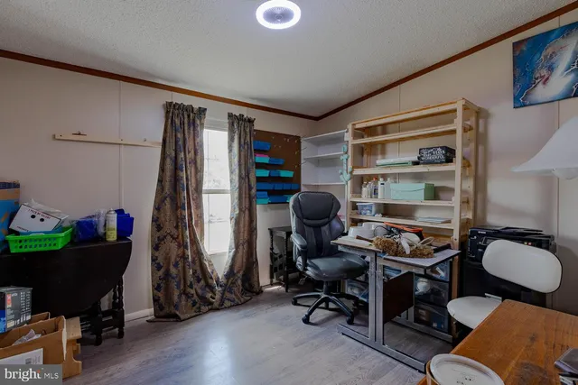 a view of a workspace with furniture and a window