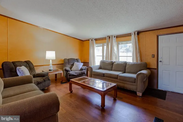 a living room with furniture wooden floor and a window