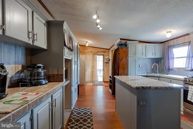 a kitchen with stainless steel appliances granite countertop a sink stove and cabinets