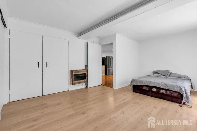 a spacious bedroom with a bed and a view of kitchen