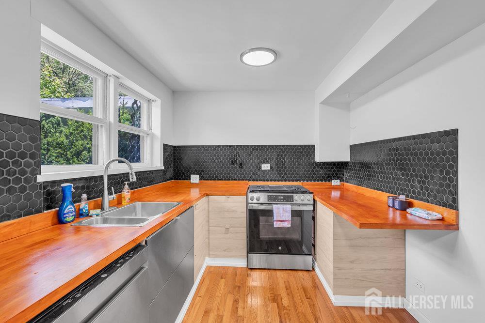21 Homestead Lane Roosevelt, NJ 08555 - Photo 2 of 24 a kitchen with stainless steel appliances granite countertop a sink and wooden cabinets