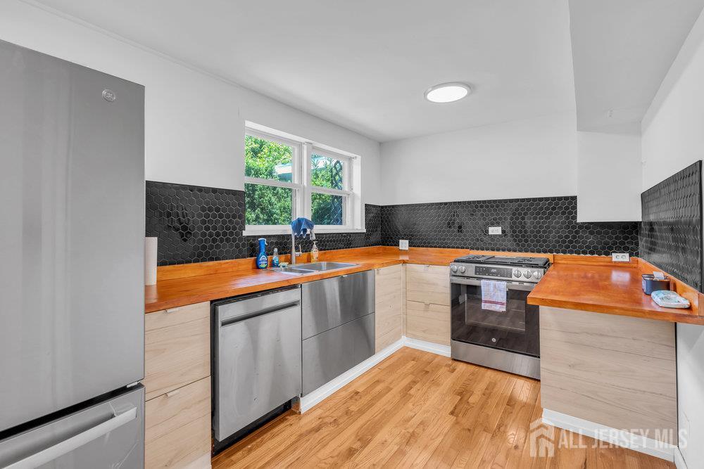 21 Homestead Lane Roosevelt, NJ 08555 - Photo 7 of 24 a kitchen with stainless steel appliances granite countertop a sink a stove top oven a counter space and cabinets