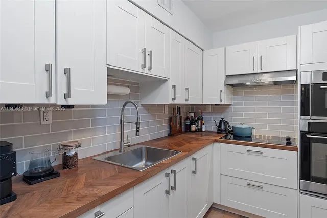 a kitchen with white cabinets a sink and dishwasher