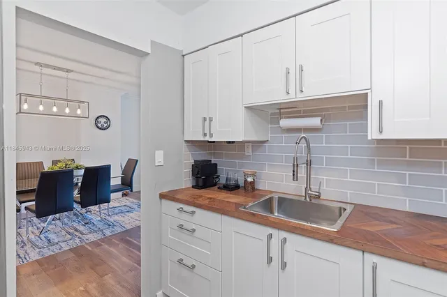 a kitchen with stainless steel appliances granite countertop a sink a stove and white cabinets