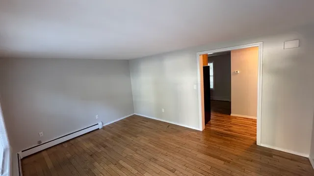 a view of an empty room with wooden floor