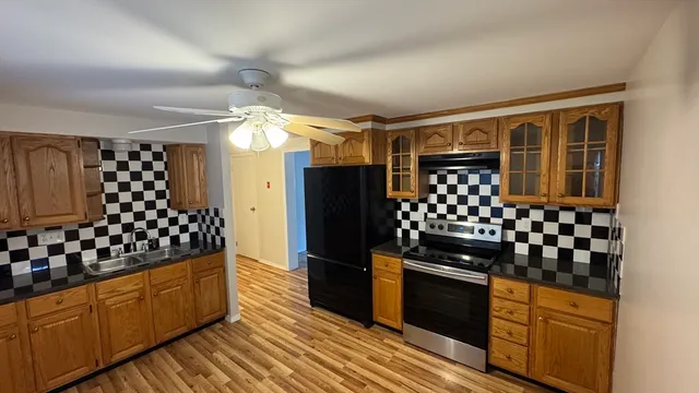 a kitchen with granite countertop a refrigerator and a stove top oven