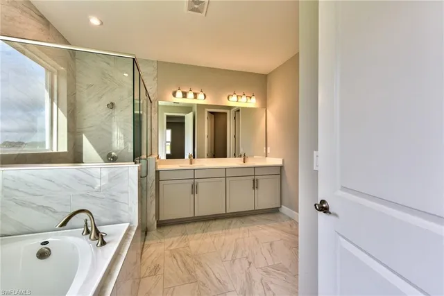 a bathroom with a sink mirror and a bathtub