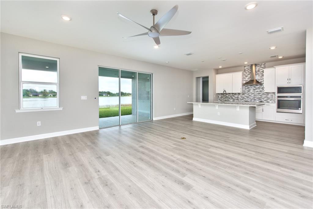 2066 Grove Drive Naples, FL 34120 - Photo 6 of 32 a view of an empty room with window and wooden floor