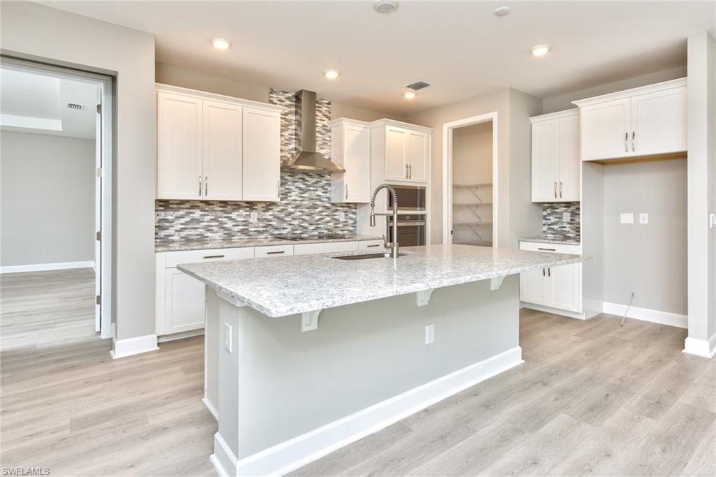 2066 Grove Drive Naples, FL 34120 - Photo 7 of 32 a kitchen with stainless steel appliances granite countertop a stove and a refrigerator