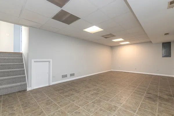 a view of an empty room with stairs and a window