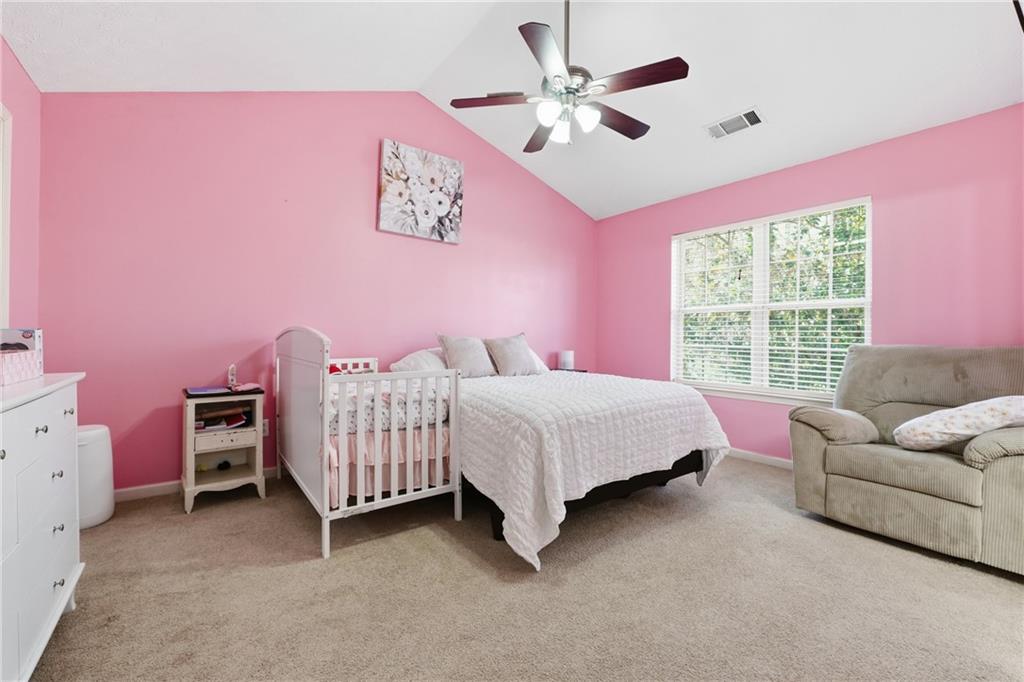 265 Springbottom Drive Southeast Lawrenceville, GA 30046 - Photo 13 of 30 a bedroom with a bed and a chandelier