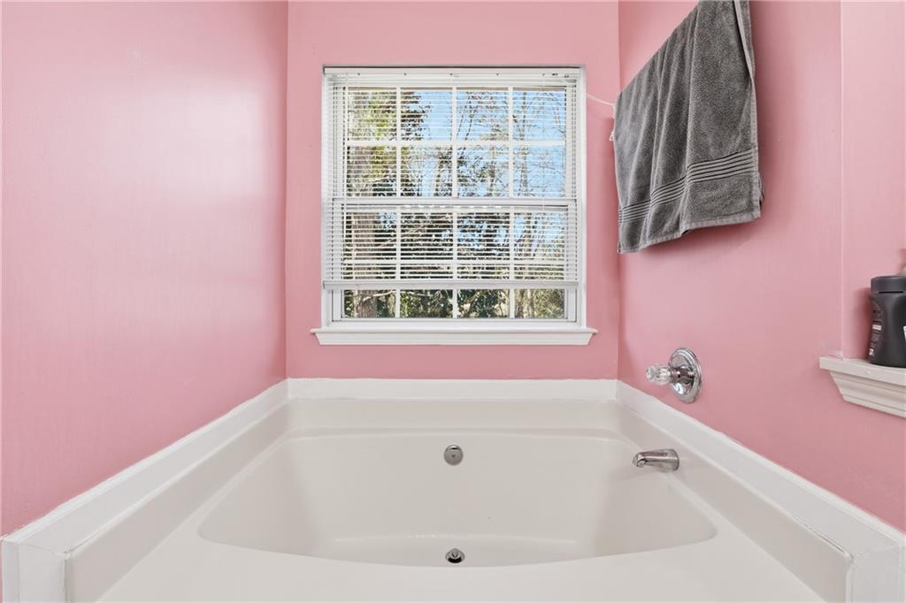 265 Springbottom Drive Southeast Lawrenceville, GA 30046 - Photo 16 of 30 a white bath tub sitting next to a window