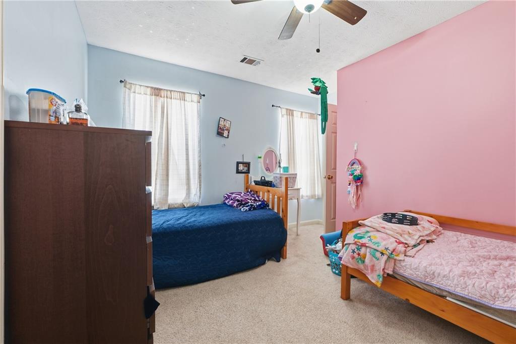 265 Springbottom Drive Southeast Lawrenceville, GA 30046 - Photo 21 of 30 a bedroom with a bed and a chandelier