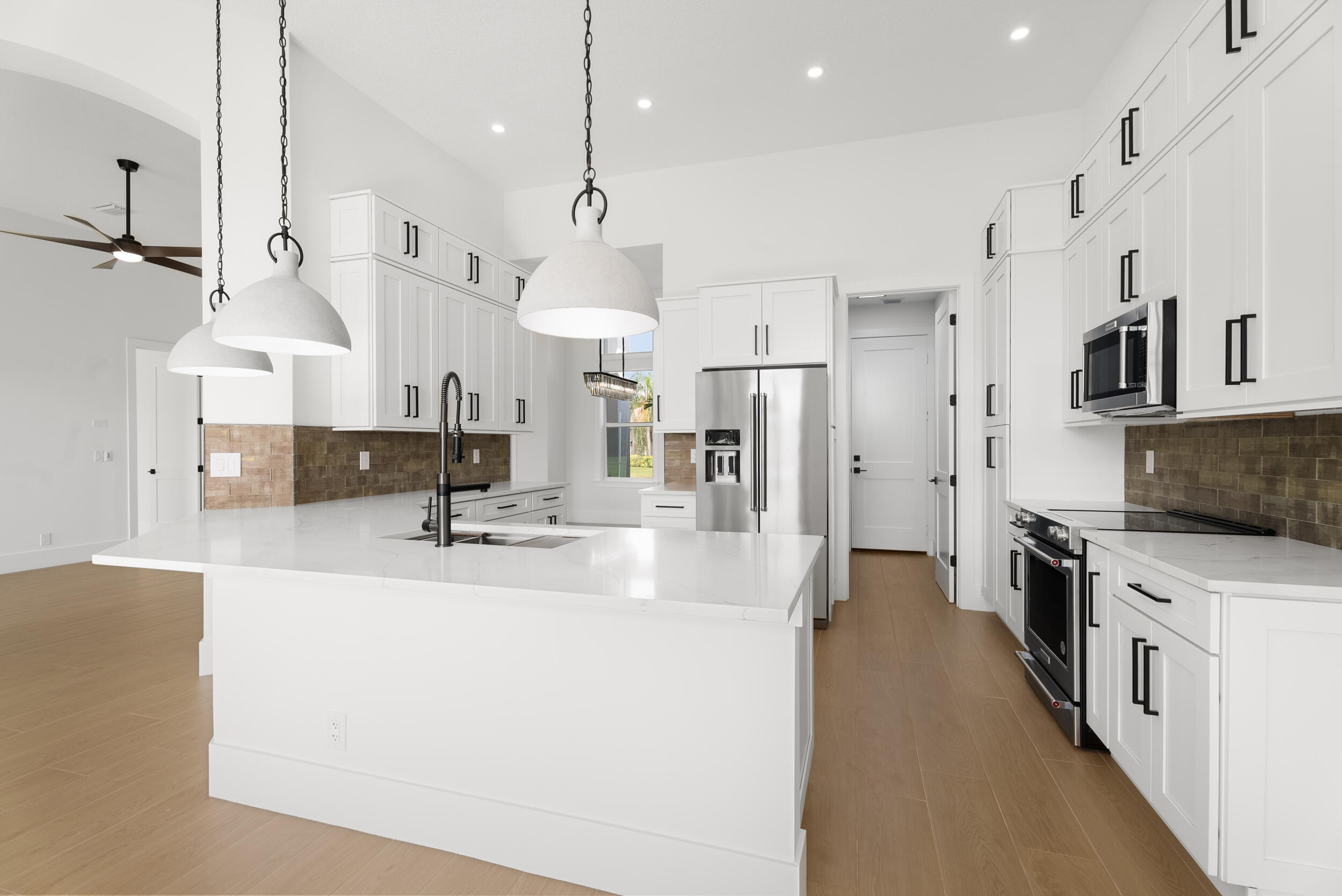 2218 Southeast Stonehaven Road Port St. Lucie, FL 34952 - Photo 16 of 48 a large kitchen with stainless steel appliances kitchen island a large counter top a sink refrigerator and cabinets