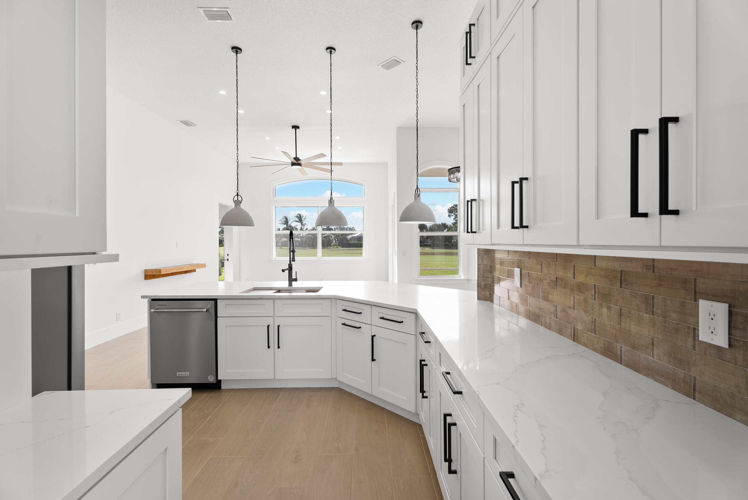 2218 Southeast Stonehaven Road Port St. Lucie, FL 34952 - Photo 18 of 48 a large white kitchen with kitchen island a sink a stove and white cabinets
