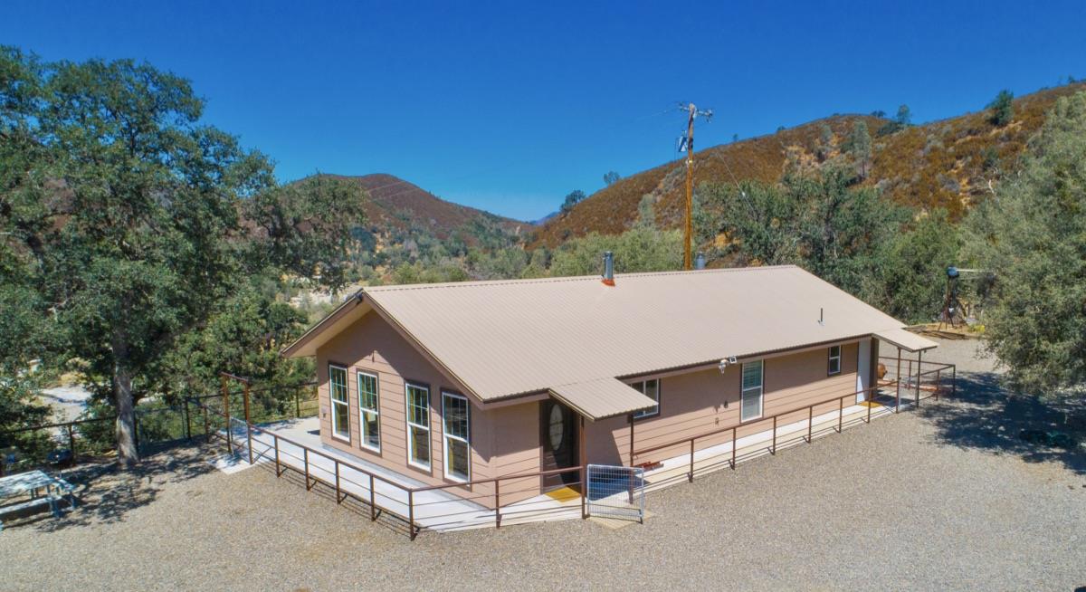 a aerial view of a house with a yard and mountain view