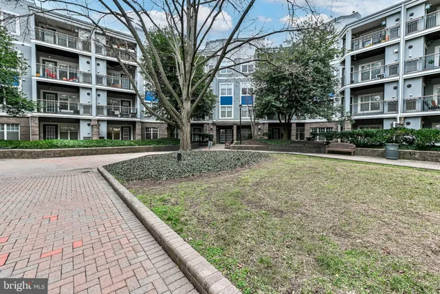 a view of residential houses with yard and trees