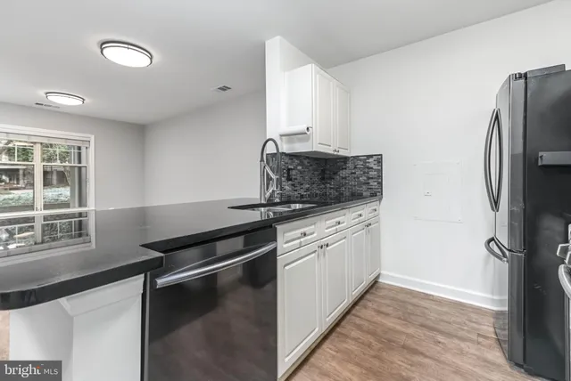 a kitchen with granite countertop a stove and a wooden floors