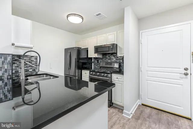 a kitchen with stainless steel appliances a refrigerator sink and stove