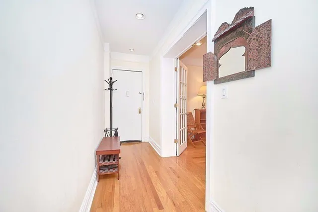 a view of a hallway with wooden floor and staircase