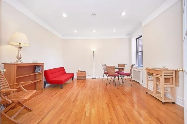 a living room with furniture a table and wooden floor