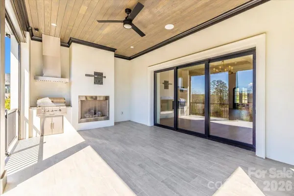 a large white room with kitchen view and wooden floor