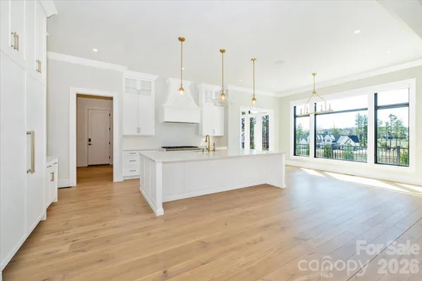 a large white kitchen with a large counter top a sink a stove and refrigerator