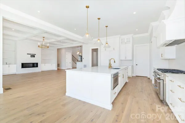 a large kitchen with granite countertop a stove and a large window