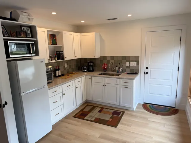 a kitchen with stainless steel appliances granite countertop a refrigerator and a sink