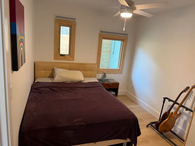 a bedroom with a bed and wooden floor