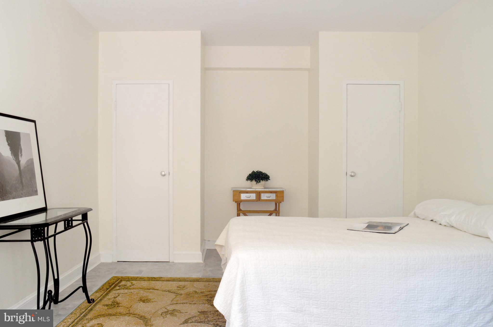 3025 Ontario Road Northwest, Unit 105 Washington, DC 20009 - Photo 12 of 26 a bedroom with a bed and a flat tv screen on the table