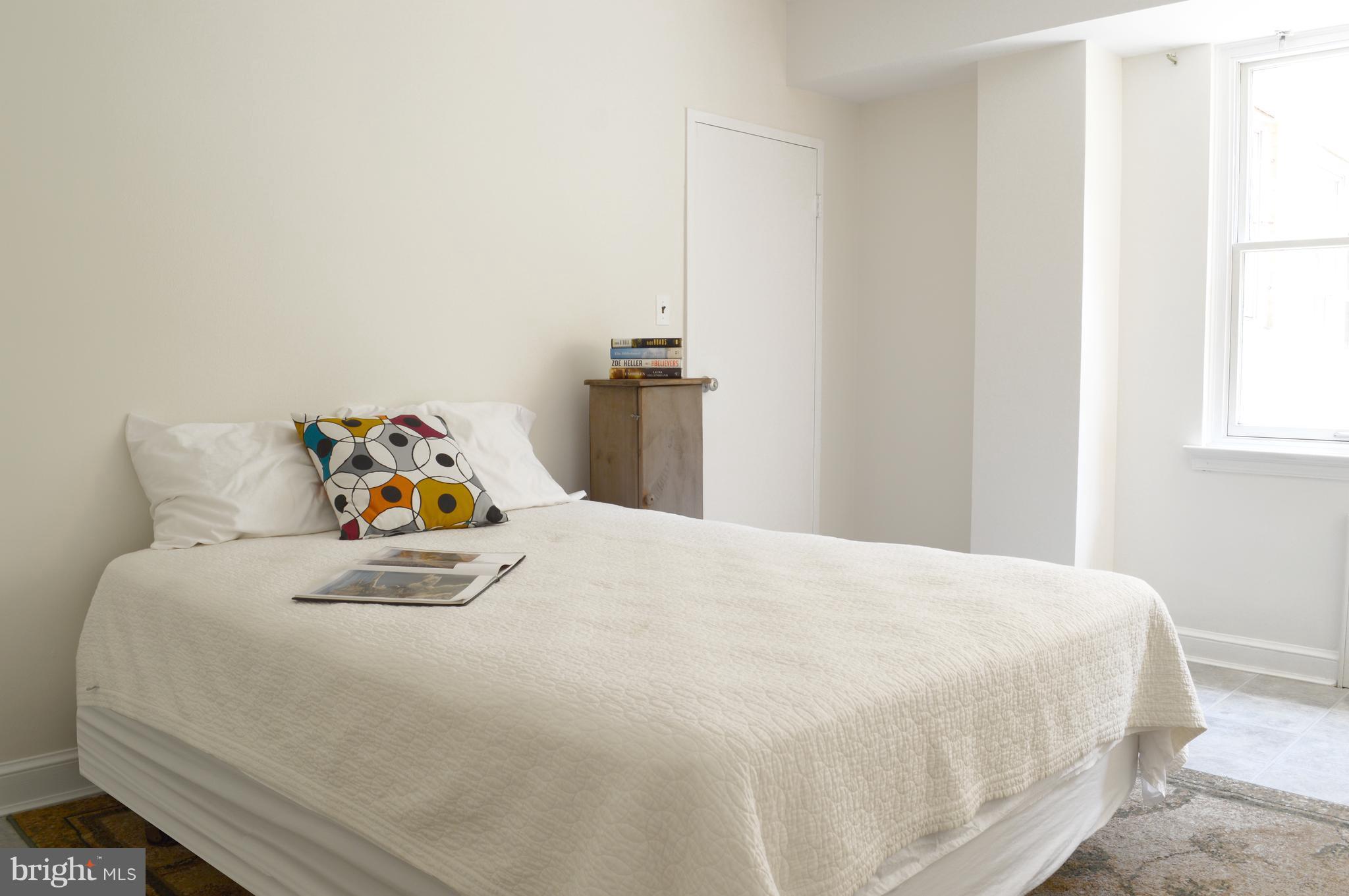 3025 Ontario Road Northwest, Unit 105 Washington, DC 20009 - Photo 13 of 26 a bedroom with a bed and a window