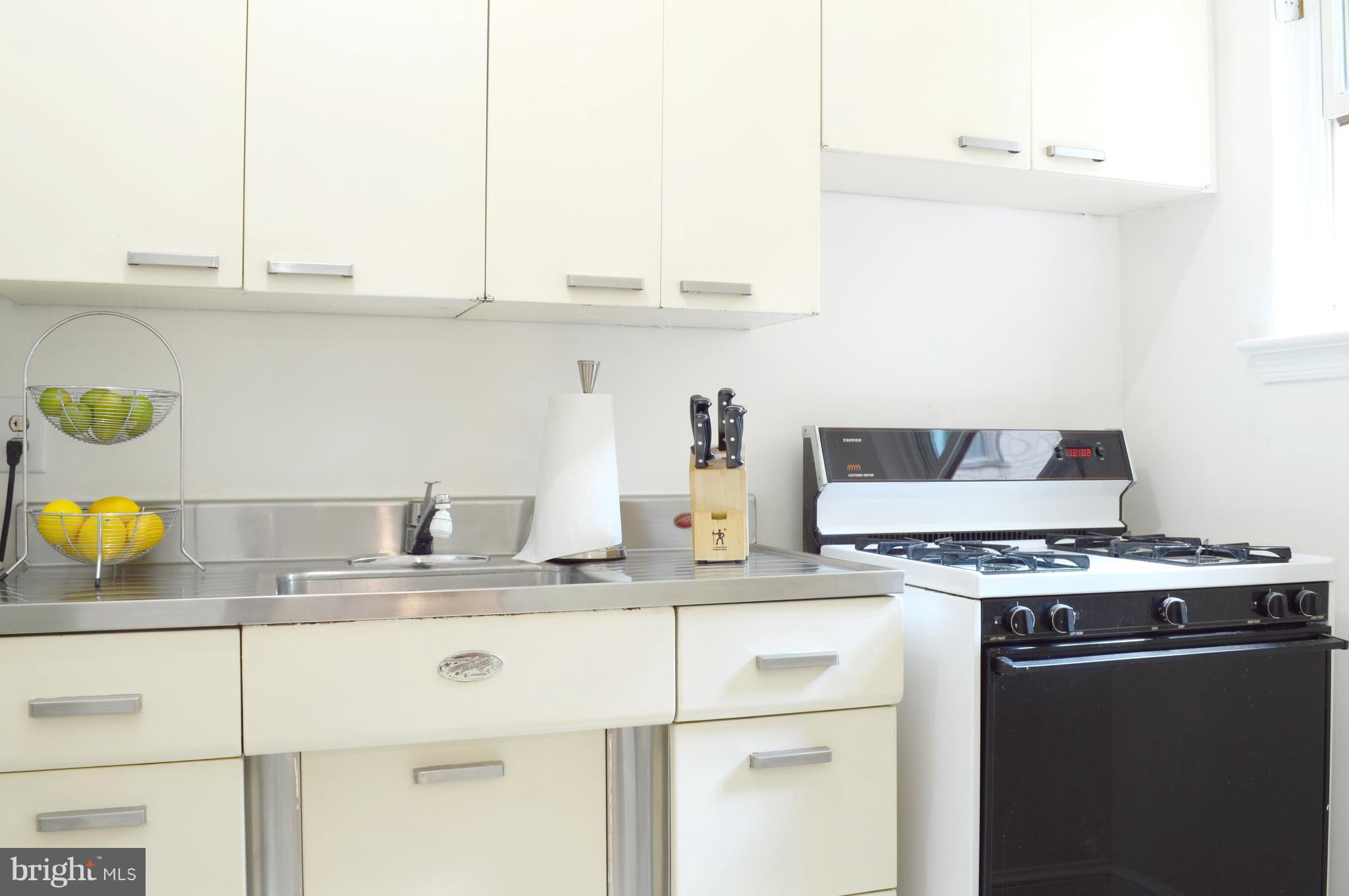 3025 Ontario Road Northwest, Unit 105 Washington, DC 20009 - Photo 8 of 26 a kitchen with a sink a stove cabinets and counter space
