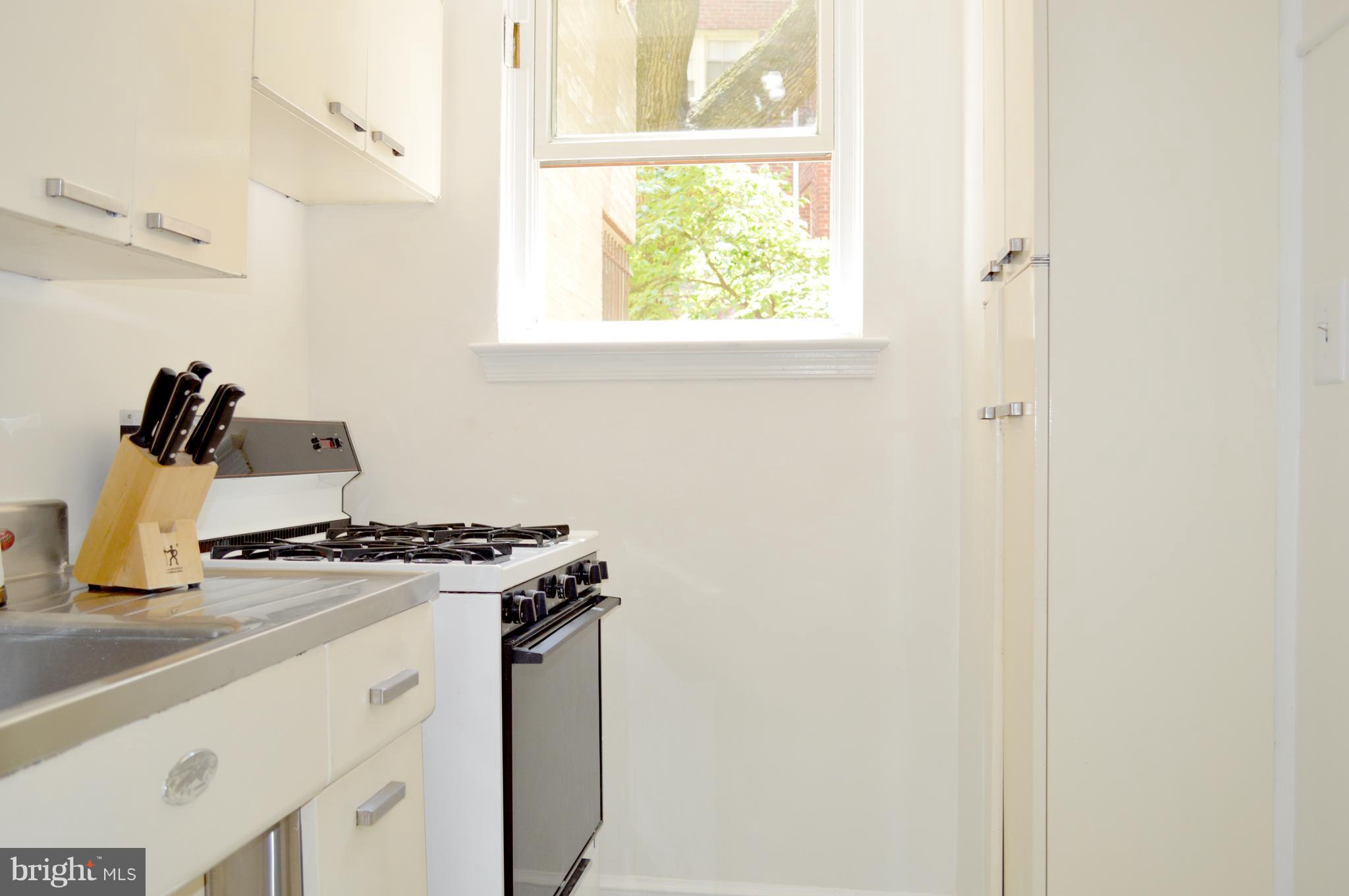 3025 Ontario Road Northwest, Unit 105 Washington, DC 20009 - Photo 9 of 26 a kitchen with a stove and a window