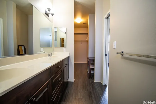 a spacious bathroom with a double vanity sink a mirror and a shower
