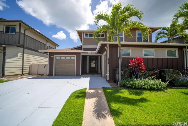 a front view of a house with yard and green space