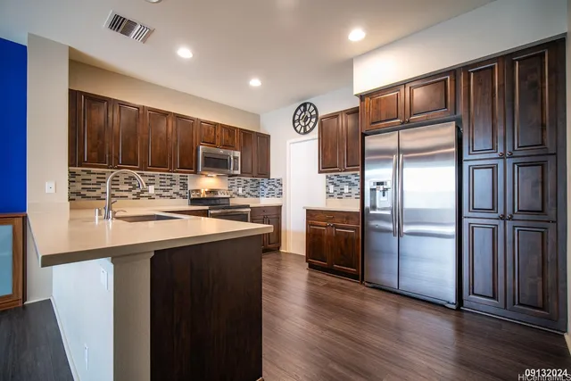 a kitchen with stainless steel appliances granite countertop a refrigerator stove and oven