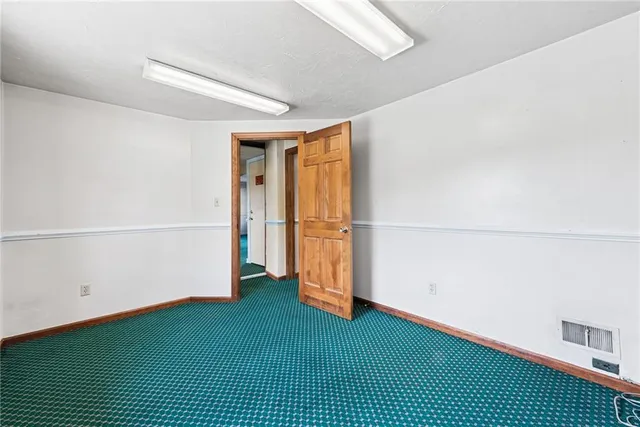 a view of an empty room with window and stairs