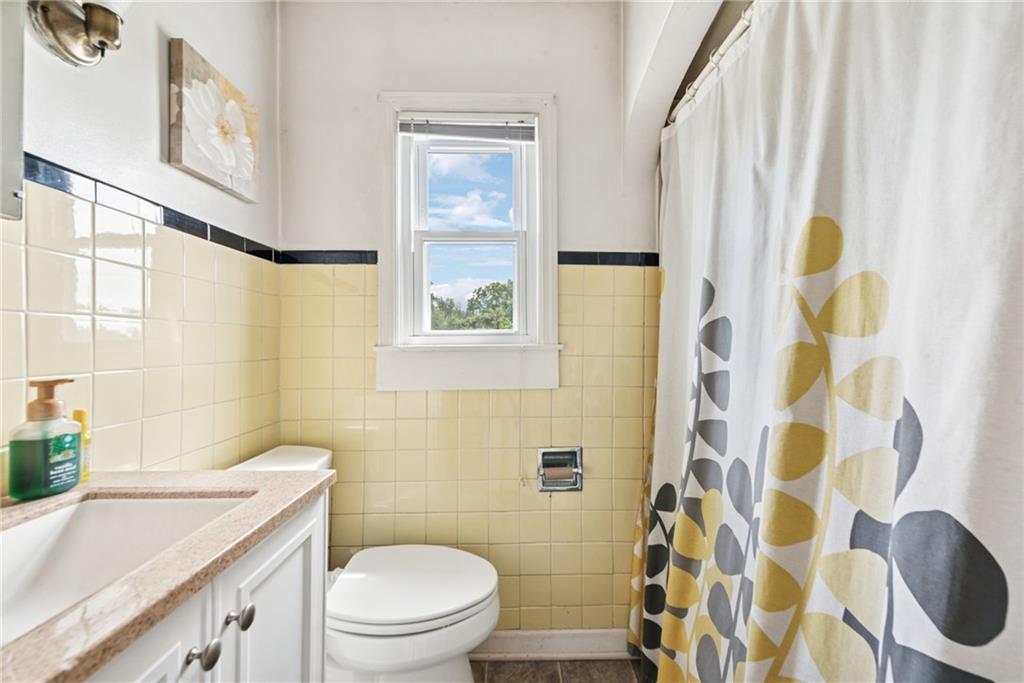 7814 Highway 30 Irwin, PA 15642 - Photo 21 of 30 a bathroom with a sink a toilet and shower curtain