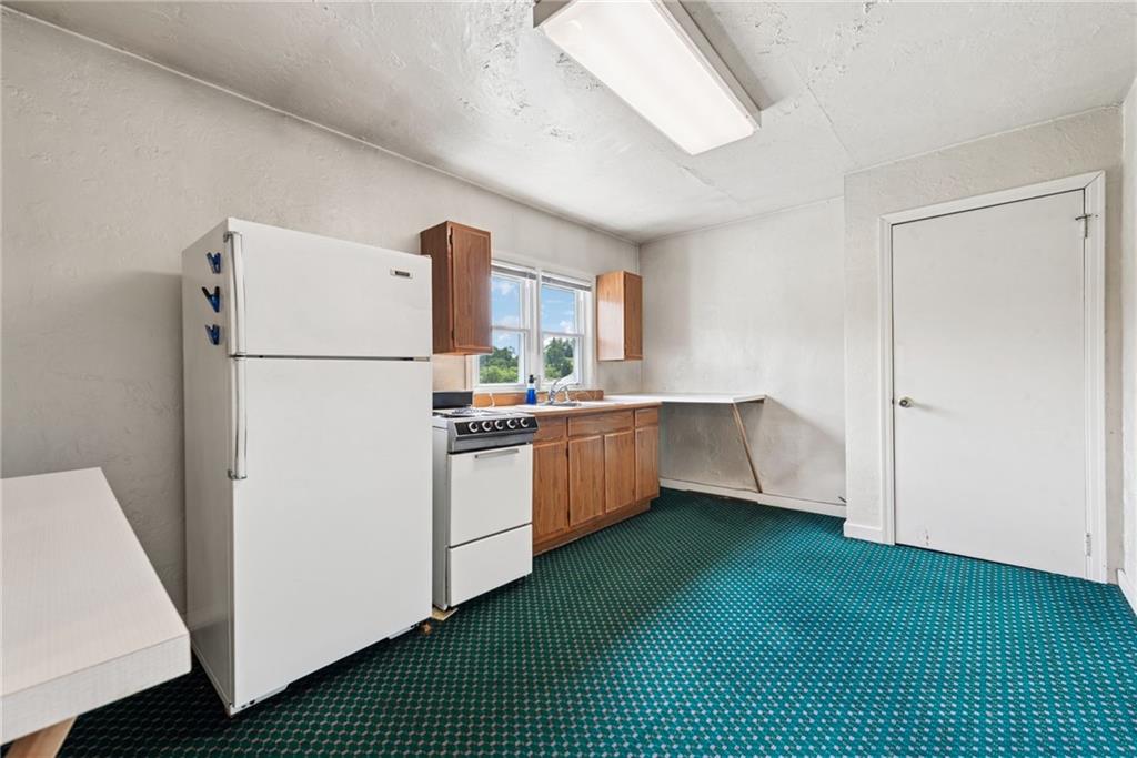 7814 Highway 30 Irwin, PA 15642 - Photo 22 of 30 a kitchen with a refrigerator a sink and a stove top oven