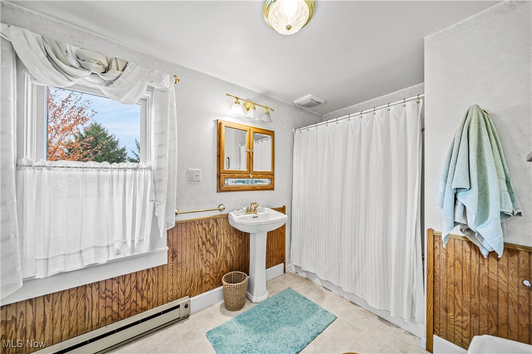 4804 Guest Road Jefferson, OH 44047 - Photo 19 of 48 Bathroom with wooden walls, sink, and a baseboard radiator