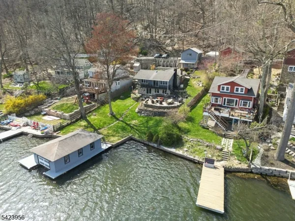 an aerial view of a house with swimming pool patio and lake view