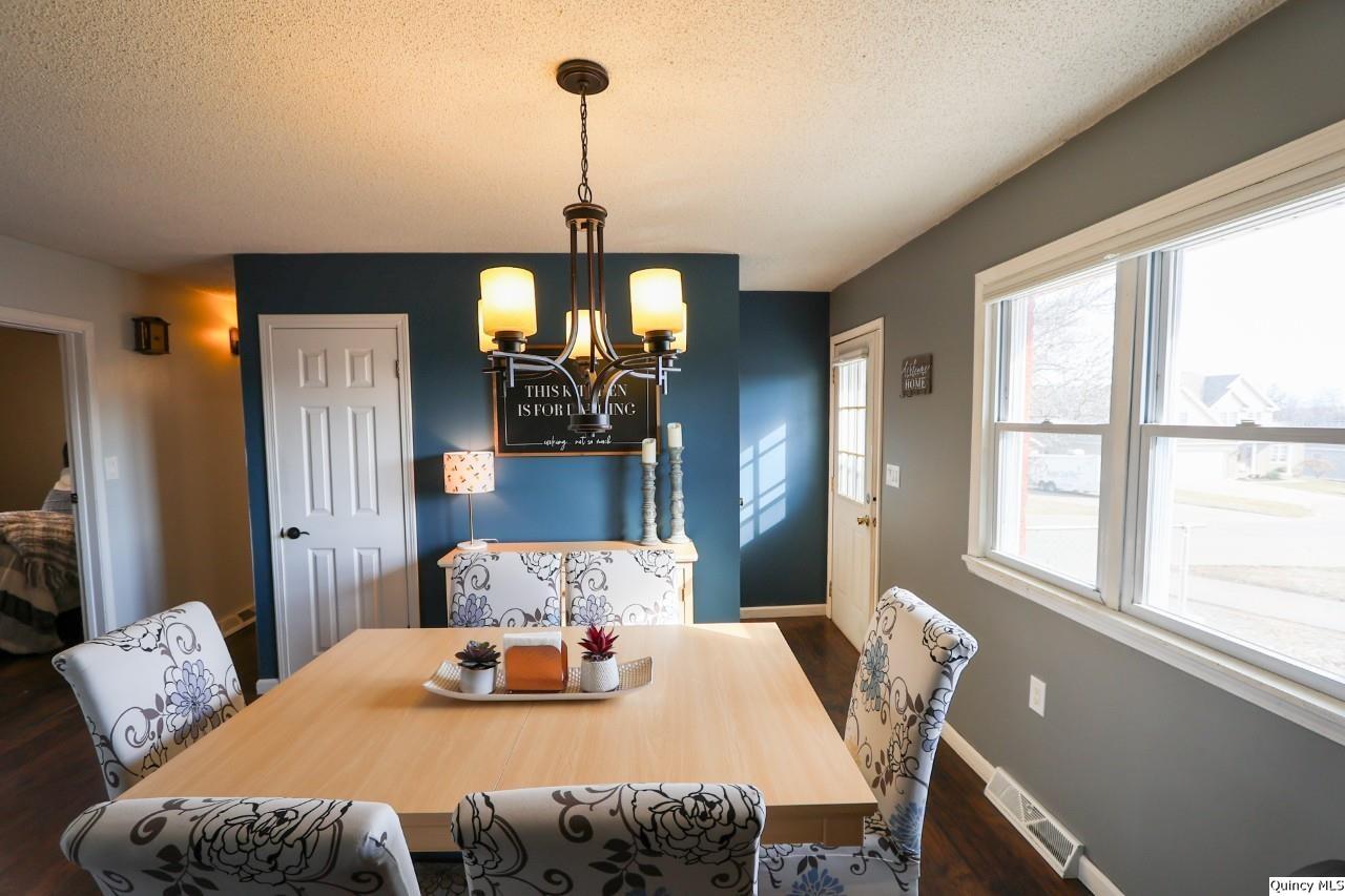 4400 State Street Quincy, IL 62305 - Photo 5 of 31 a view of a dining room with furniture a chandelier and wooden floor