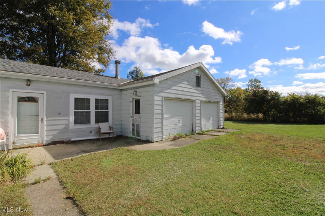 5084 West Fremont Road Port Clinton, OH 43452 - Photo 7 of 19 Rear view of house with a lawn, an attached garage, and a shingled roof