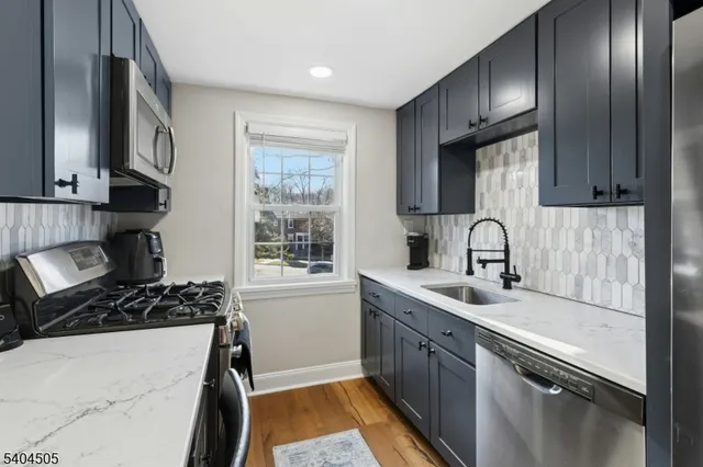 a kitchen with stainless steel appliances a sink stove and cabinets