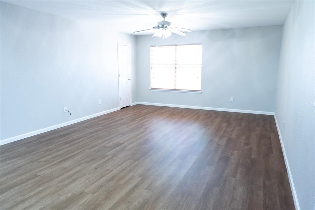 8805 Graywolf Ridge Trail Fort Worth, TX 76244 - Photo 16 of 23 Spacious interior room featuring wood-finish flooring, light-toned wall paint, and a ceiling fan with integrated lighting
