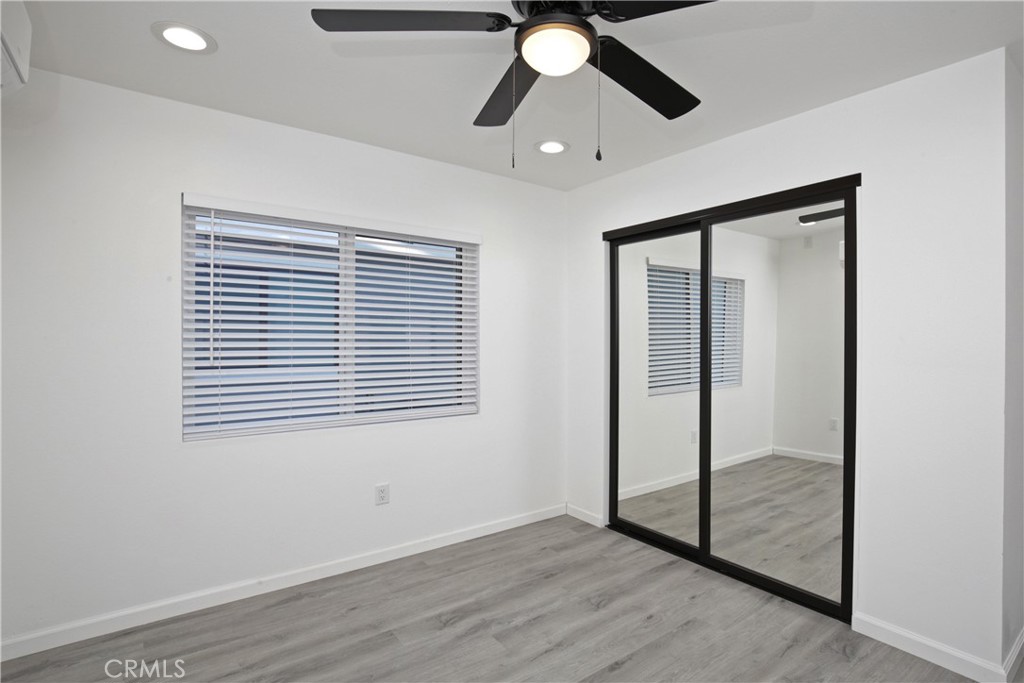 6147 Palm Avenue Riverside, CA 92506 - Photo 3 of 13 an empty room with wooden floor fan and windows