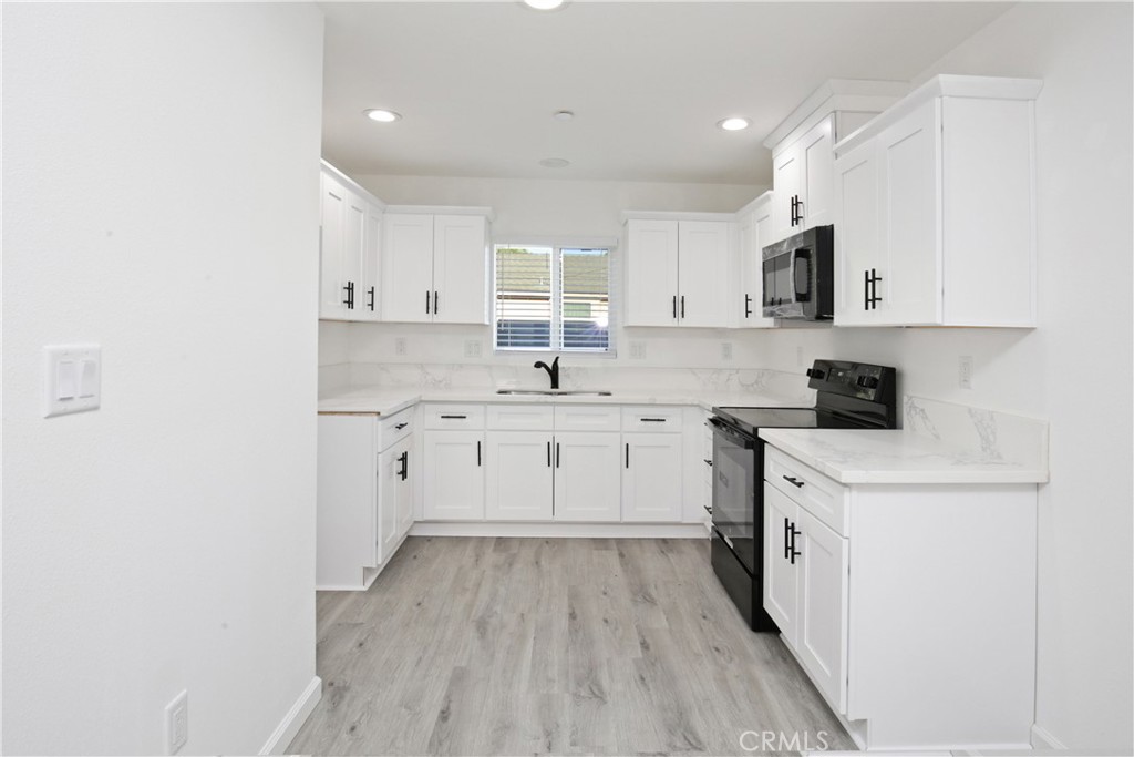 6147 Palm Avenue Riverside, CA 92506 - Photo 7 of 13 a kitchen with white cabinets stainless steel appliances and sink