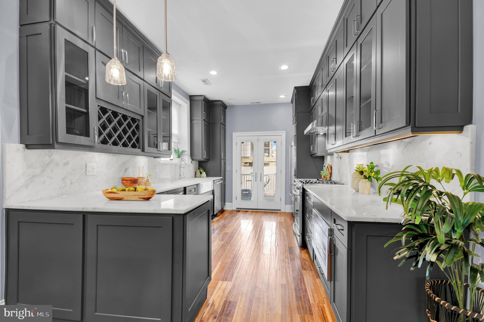 1915 2nd Street Northwest Washington, DC 20001 - Photo 18 of 76 a kitchen with stainless steel appliances a sink a wooden floor cabinets and a potted plant