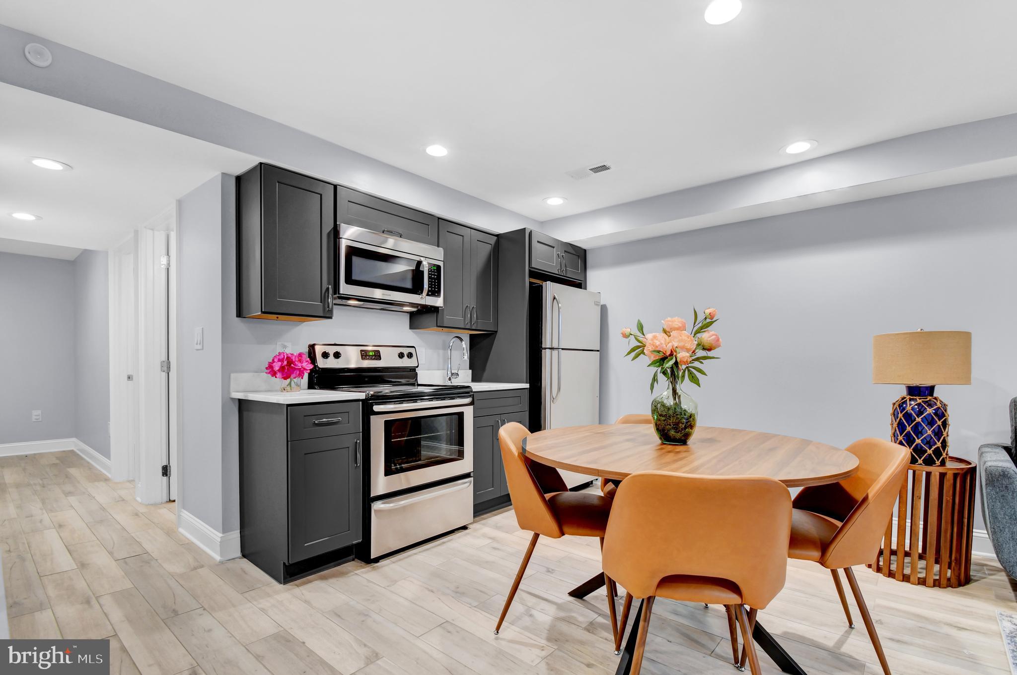 1915 2nd Street Northwest Washington, DC 20001 - Photo 48 of 76 a kitchen with stainless steel appliances a stove a sink dishwasher a refrigerator and a dining table with wooden floor